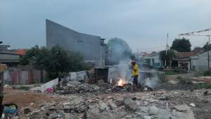 Seorang pria tengah membakar sampah di RW 016 Kampung Rawa Barat, Pondok Pucung, Kecamatan Pondok Aren, Tangsel.