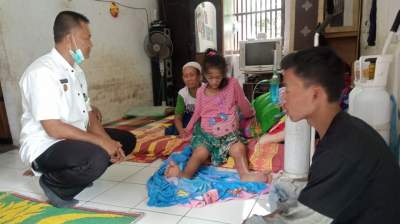 Tubuh kurus Enah terduduk didepan lurah Roni Rohimat. Enah dan anaknya butuh segera tindakan medis.