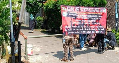 Salah satu gerbang sekolah yang ditutup oleh warga.