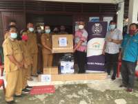 Head of Corporate Affairs, PT Aqua Farm Nusantara, David Tampubolon menyerahkan bantuan kepada sekolah di Ajibata, Toba.