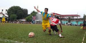 Kapten Beringin Serut, Imam (jersey kuning) menangkan duel perebutan bola dengan pemain Madura FC, Fransisco (jersey merah-hitam). Beringin Serut lolos kebabak 16 besar melalui adu penalti dengan skor 4-3.