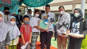 Ketua PGRI Cabang Ciputat di dampingi Ketua PGRI Tangsel Cartam, berikan santunan anak yatim di SD Negeri 04 Ciputat.