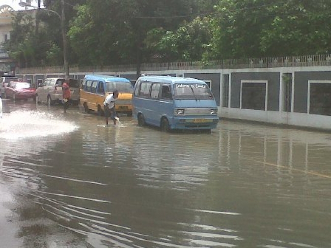Tampak kubangan air ketika hujan turun di sepanjang Jalan Raya Serang