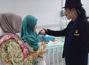 Ketua Pagar Nusa NU Provinsi Banten, Mohamad Nasir saat menjenguk balita mengidap infeksi paru-paru.