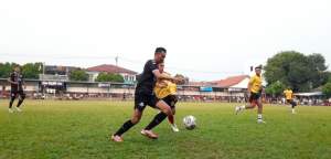 Penyerang Bingunk, Yasril (jersey hitam) menggiring bola dibayang-bayangi bek Arkha Mandiri, Basroh (jersey kuning) dalam laga babak 16 besar Pakujaya Cup 8.