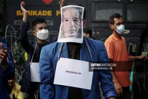 Demonstran mengenakan topeng foto bergambar wajah Jokowi pada aksi demo pekan lalu Kamis (21/10/2021).