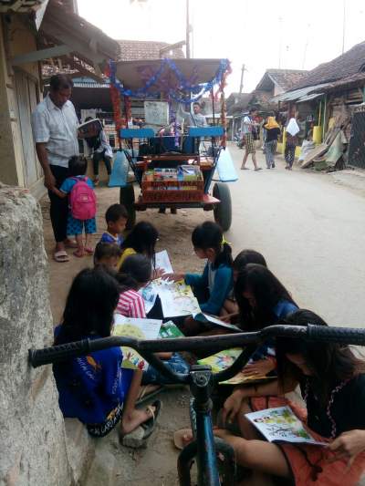 Anak-anak membaca buku dari Kuda Pustaka Kusmayadi