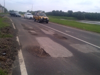 Tampak jalan berlubang di Jl Perimeter selatan dan utara Bandara Soetta