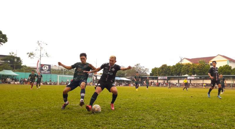 Pemain Bingunk Dolly Gultom  (jersey hitam) duel berebut bola dengan penyerang Meox, Bagas (jersey hijau) di babak 32 besar Pakujaya Cup 8.