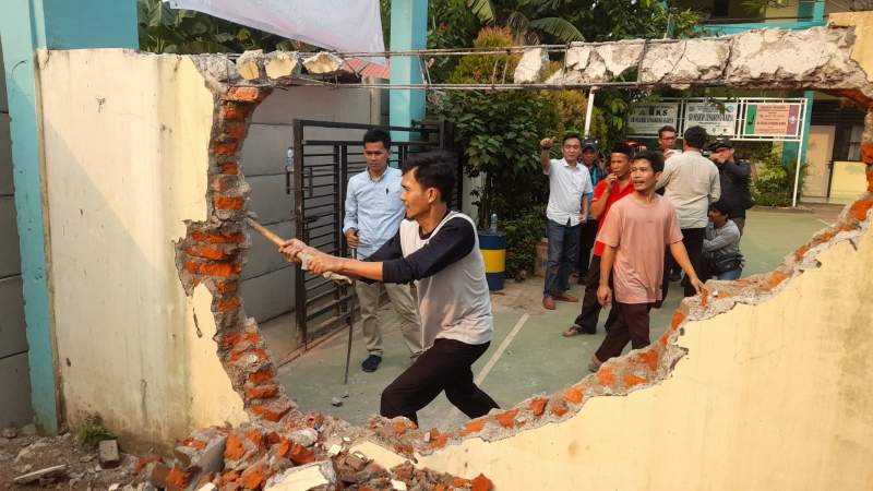 Pekerja saat menggempur tembok lama didepan SD Negeri Lengkong Karya yang akan digunakan sebagai akses baru sekolah tersebut.