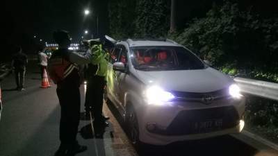 Petugas Polda Banten saat mengecek kendaraan terkait adanya larangan mudik di Gerbang Tol Merak, Kota Cilegon, Sabtu (25/4) malam.&nbsp;