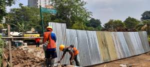 Sejumlah pekerja  tengah memasang seng penutup agar kendaraan tidak melewati jembatan kali Angke yang tengah dilakukan perbaikan.