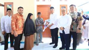 Walikota Benyamin Davnie disaksikan Kepala Disperkimta, Aries Kurniawan dan Ketua DPRD Tangsel Abdul Rasyid saat menyerahkan kunci rumah kepada salahsatu warga Kecamatan Setu.