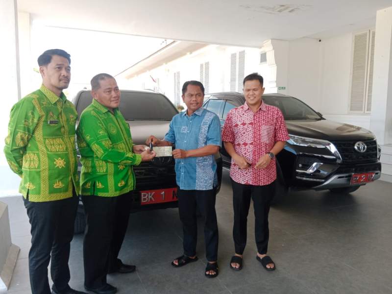 Darma Wijaya dan Adlin Tambunan menyerahkan mobil dinas ke Pemkab Serdang Bedagai.