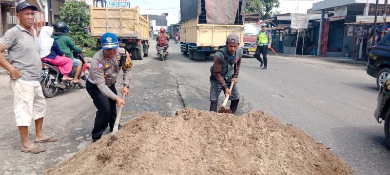 Kasat lantas Polres Serdang Bedagai, Iptu Andita Sitepu menimbun lubang di Jalinsum.