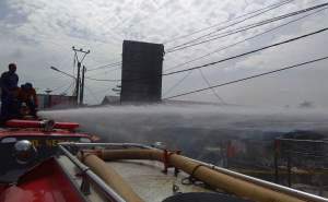 Petugas Damkar Kabupaten Serang menyemprotkan air untuk pendinginan api saat kebakaran di Pasar Ciruas.